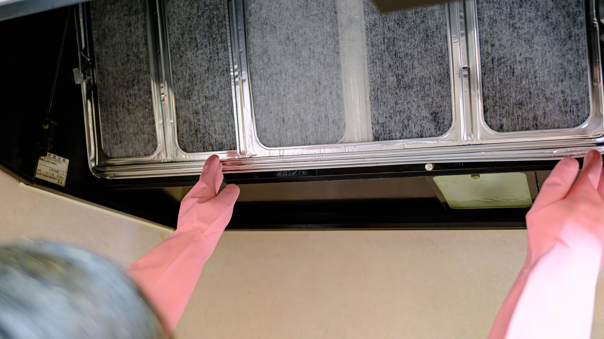 Hands cleaning window with textured glass and metal frame