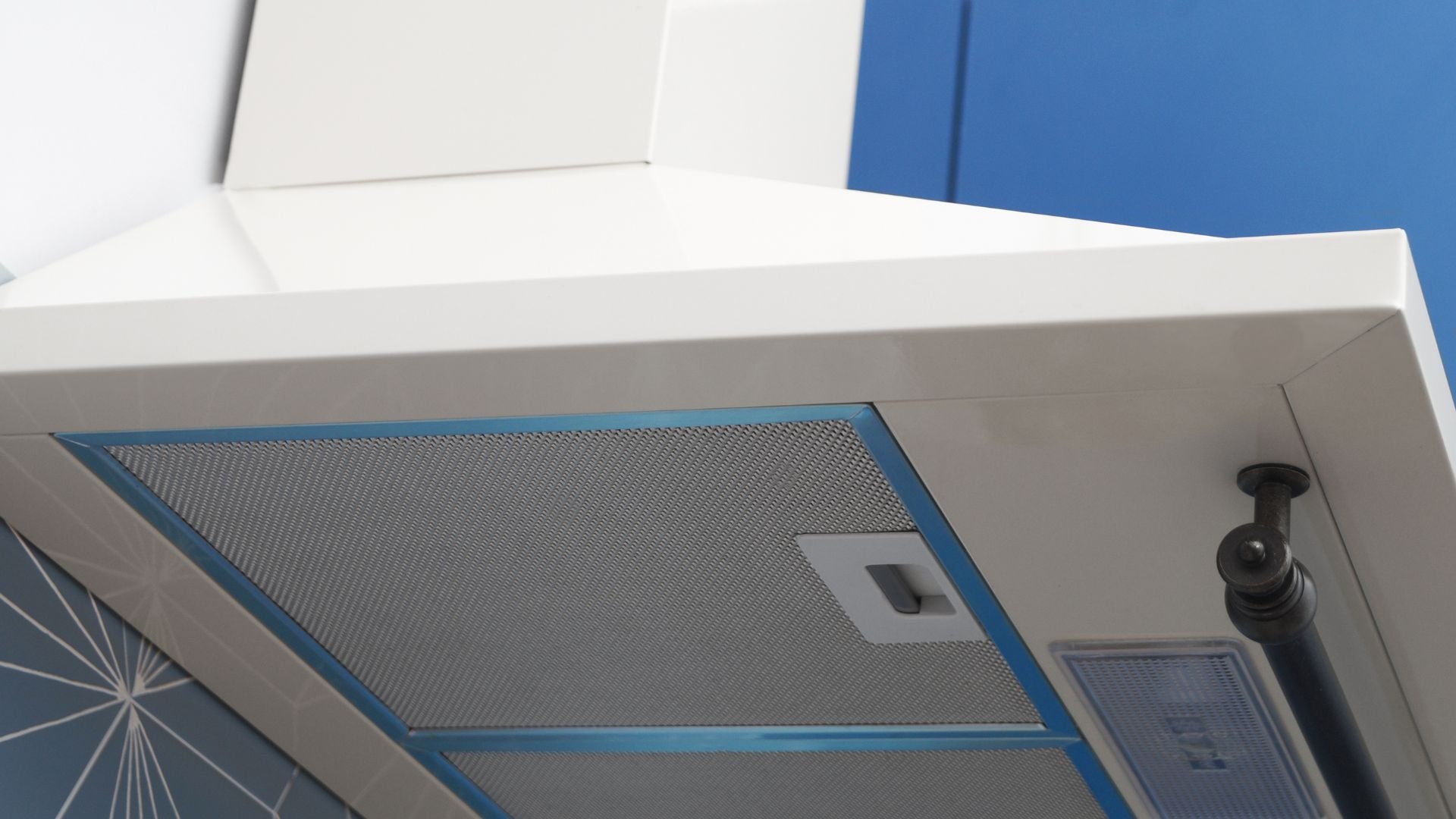 Modern kitchen range hood with metallic mesh filter and blue accents